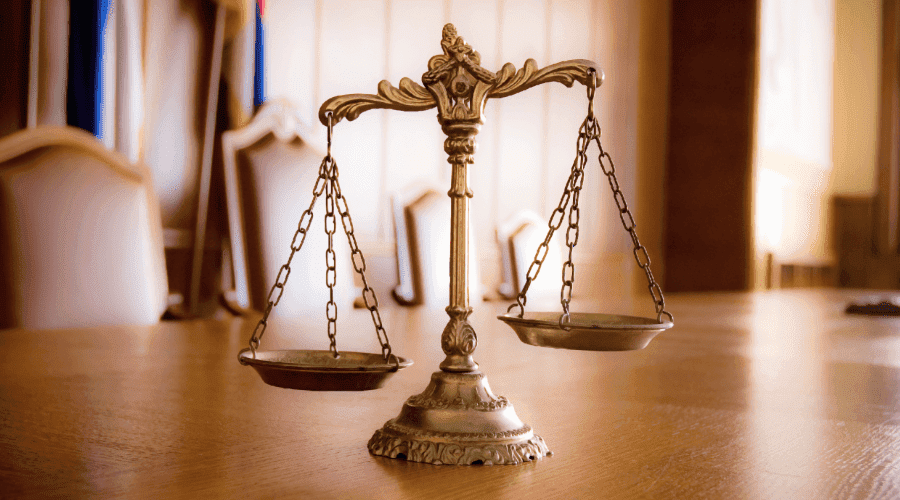 Photo of justice scales sitting on a table in a US courtroom.