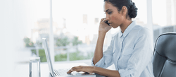 Woman on the phone and working on her laptop