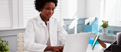 A healthcare professional at her computer searching the SAM System for Award Management.