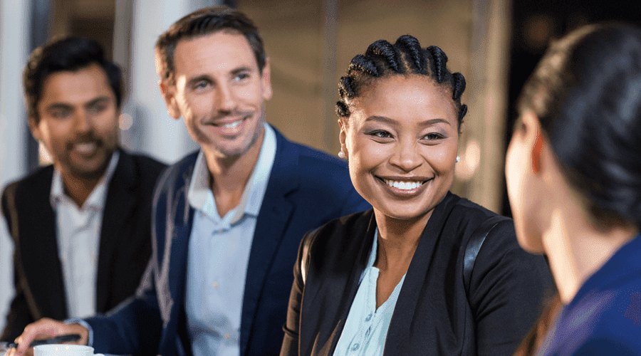 Diverse employees in a meeting include two men and two women