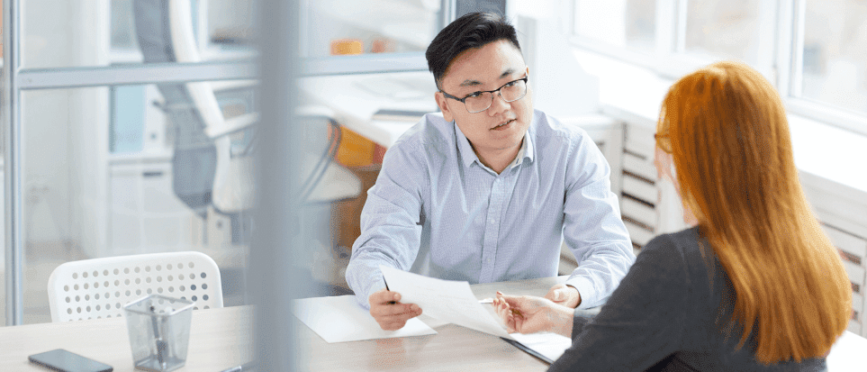 A hiring manager is assessing a young woman's skills during a job interview.