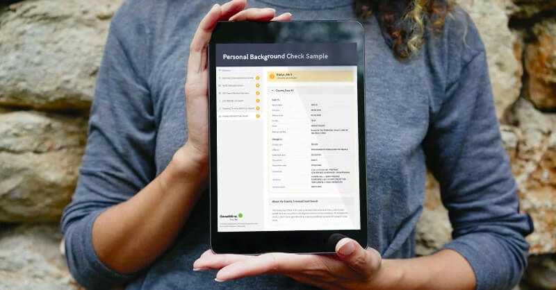 Woman holding a tablet with her personal background check results from GoodHire